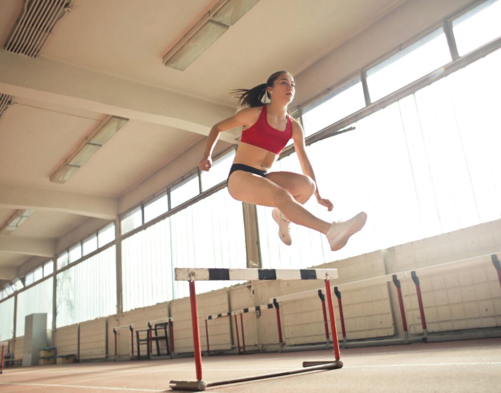 Fille athlète saute un obstacle