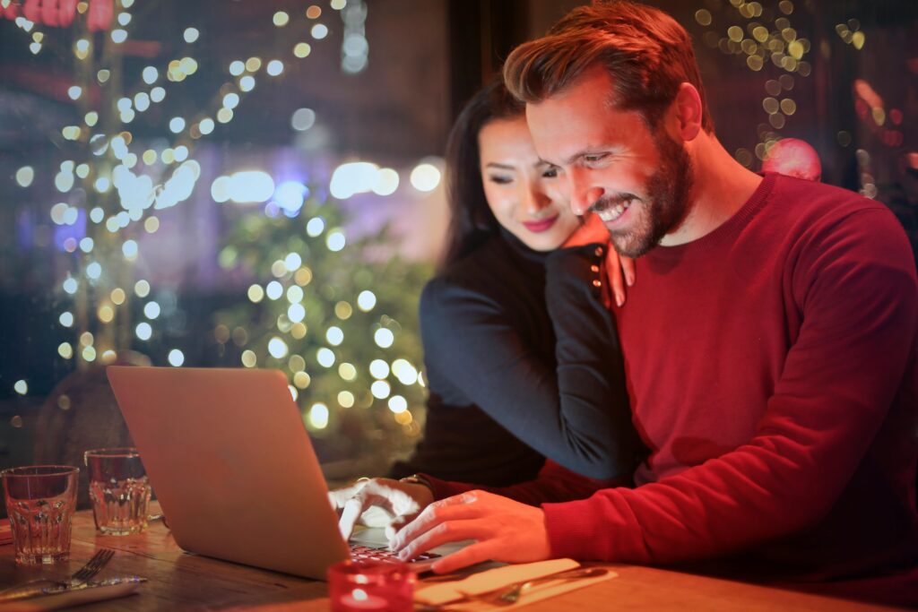 Homme et femme regardent contents l'écran de leur ordinateur portable