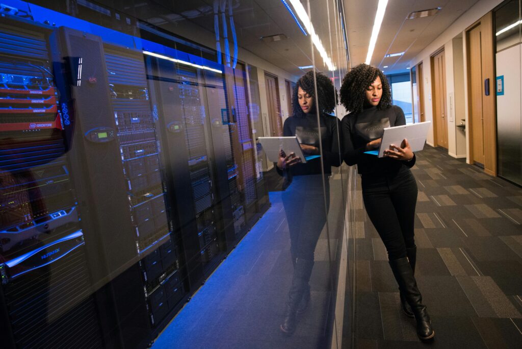 Femme technicienne avec son PC portable fait un diagnostic d'un grand serveur